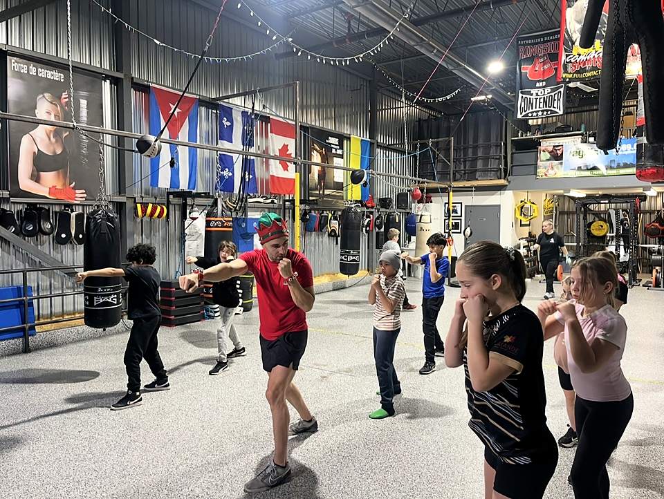 Un entraîneur guide un exercice de coups de poing avec un groupe d'enfants